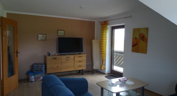 Wohnzimmer der Ferienwohnung Haus mit Ecksofa und Fernseher